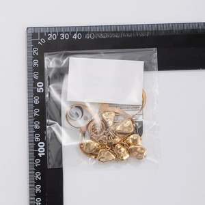 Detailed view of golden snake chain with heart charms and sizing scale for reference