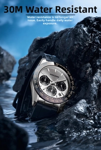 Waterproof chronograph watch with silver dial on wet black rocks with water splashes