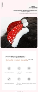 Macro shot of red acrylic Christmas claw clip with white snowflake patterns and snow edge