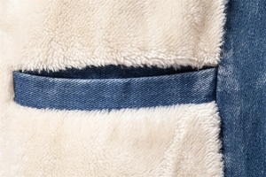 Detail view of denim jacket with thick white fleece lining for winter warmth