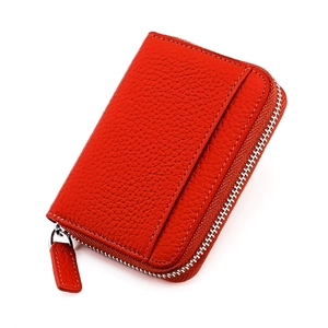 Dettaglio del porta carte in pelle rossa con cerniera argentata e texture a grana fine