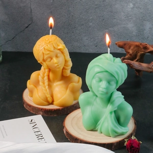 Artistic female bust scented candles in yellow and green on a wooden slice base