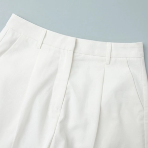 Detailed view of white high-waist suit shorts featuring premium woven texture and neat stitching