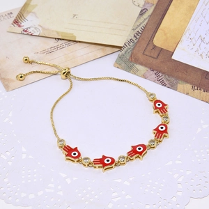 Adjustable golden Hamsa Hand bracelet with red enamel evil eye charms and crystals