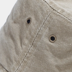 Detail of metal eyelets and double-stitched canvas fabric on a washed retro bucket hat
