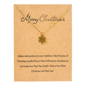 Detailed view of golden snowflake pendant necklace displayed on a Merry Christmas gift card