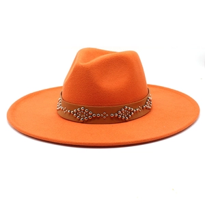 Dettaglio cappello fedora in lana arancione con fascia in pelle marrone e borchie argento