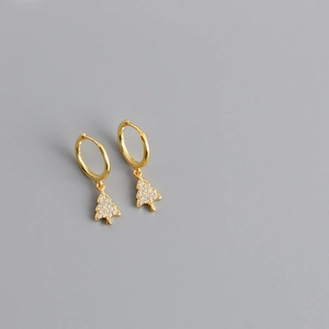 Close-up of golden Christmas tree drop earrings featuring white zircon inlay on gray background