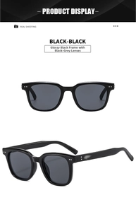 Detail view of glossy black sunglasses with dark gray lenses and silver metal studs