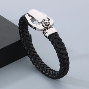Close-up of black braided leather bracelet with silver lion head metal buckle detail