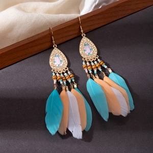 Detail of bohemian long fringe earrings featuring blue and pink feathers with beads