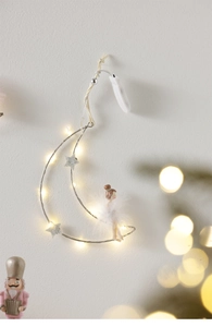 Detail of moon-shaped Christmas hanger with LED lights and fairy figure decor