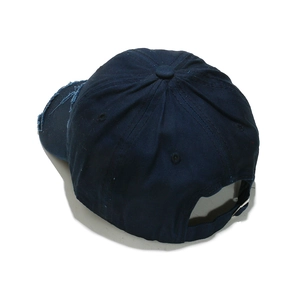 Detail view of navy blue cotton baseball cap with distressed brim and metal back buckle