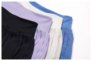 Detail view of pleated yoga skirts in black, purple, beige, and blue with elastic waist