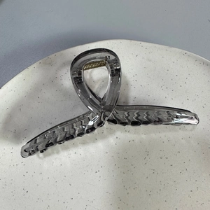 Detail view of large 13cm dark gray translucent shark hair clip with metal spring