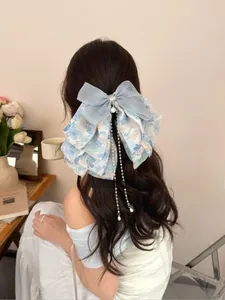 Détail d'une pince à cheveux à nœud bleu sel de mer avec tissu fleuri et perles