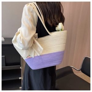 Fashionable woven tote bag in cream and lavender with lace details shown on a model