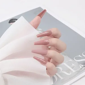 Détail de faux ongles longs ballerine rose poudré mat sur une main de mannequin