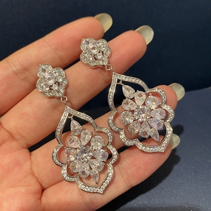 Detailed close-up of silver zircon hollow flower earrings with intricate crystal inlay