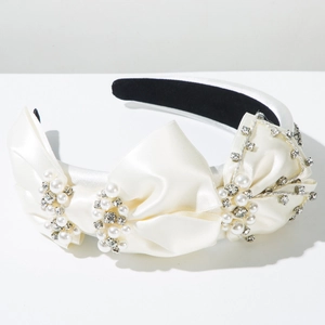Détail du serre-tête en satin avec perles élégantes et nœud orné de strass brillants