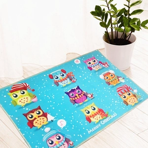Christmas blue mat with Merry Christmas text and cartoon owl on light wood floor