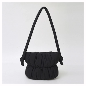 Close-up of black quilted cloud shoulder bag with soft nylon texture and ruched details
