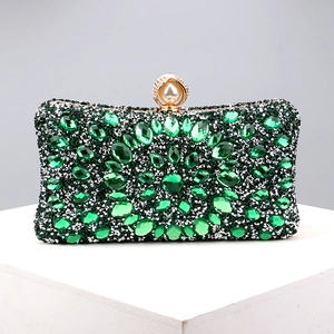 Detailed macro view of deep green crystals and pearl clasp on luxurious evening clutch bag