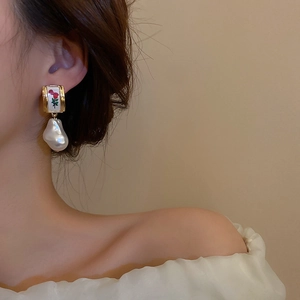 Vintage gold earrings with red rose pattern and white baroque pearl on elegant model