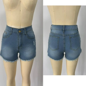 Detail of high waisted light blue denim shorts with distressed raw hem and frayed edges
