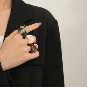 Three-piece colorful marbled resin ring set in dark green, ivory, and amber for women
