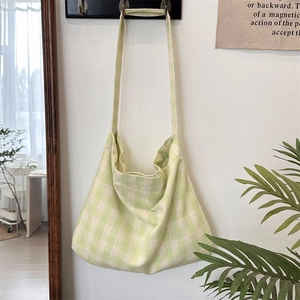 Close-up of green and white checkered knit tote bag with thick woven texture and strap