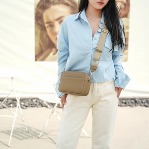 Detail of khaki pebbled PU leather camera bag with a wide fabric shoulder strap