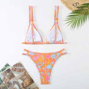 Close-up of floral bikini set with double straps and flat lay tropical beach accessories