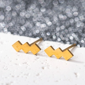 Macro shot of geometric gold stainless steel earrings with a brushed matte finish