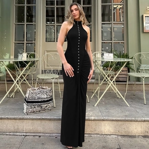 Detalle del vestido largo negro de cuello halter con botones metálicos decorativos
