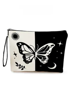 Detail showing butterfly moon pattern on canvas makeup bag with a black zipper and strap