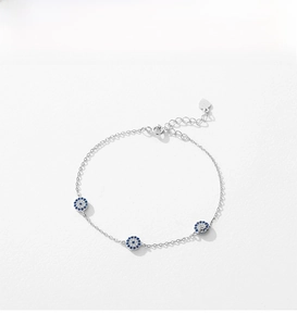 Macro detail of S925 sterling silver evil eye bracelet with blue zircon and heart tag