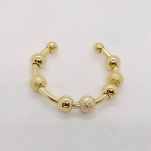Detailansicht eines goldenen Anti-Angst-Rings mit drehbaren glatten und matten Perlen