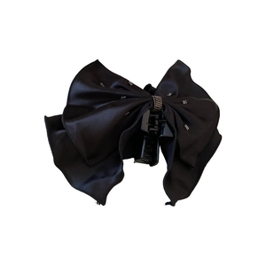 Pince à cheveux élégante en satin noir avec nœud et strass sur fond blanc