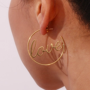 Close-up of gold large hoop earrings featuring handwritten Love lettering design