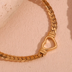 Detailed macro view of 18K gold plated hollow heart pendant on a Cuban chain necklace