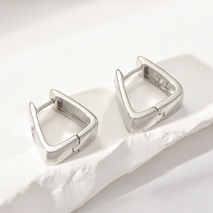 Detail of silver geometric triangle hoop earrings with sparkling cubic zirconia inlay