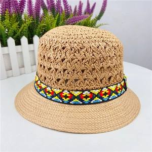 Detail of hollow-out weave pattern and ethnic colorful embroidered band on straw hat