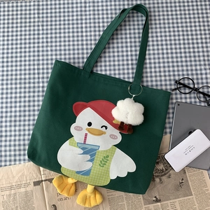 Detail of dark green canvas duck tote bag with plush cloud charm and cartoon design