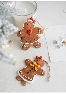 Detailed shot of Christmas gingerbread man resin ornaments with red bows and twine hangers