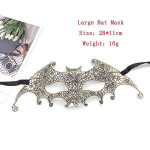 Detail view of a 28x11cm gold bat-shaped lace masquerade mask with black ribbons