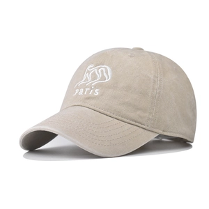 Close-up of embroidered white Paris logo on washed light khaki cotton baseball cap