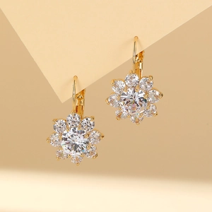 Macro shot of gold floral earrings with a large center zircon and eight petal-shaped crystals
