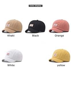 Flat lay of short brim baseball caps in khaki, black, orange, white and yellow colors