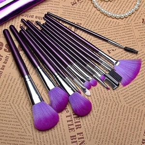 Lot de 16 pinceaux de maquillage violets avec viroles argentées sur papier journal